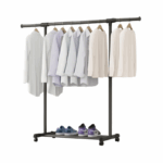 Zwart kledingrek met hangende shirts en schoenen op de onderplank