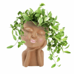 plantenhouder in de vorm van een rustgevend gezicht met gesloten ogen en groene bladeren als speels kapsel.