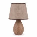 Keramische schemerlamp met stijlvolle voet en warme sfeerverlichting op witte achtergrond.